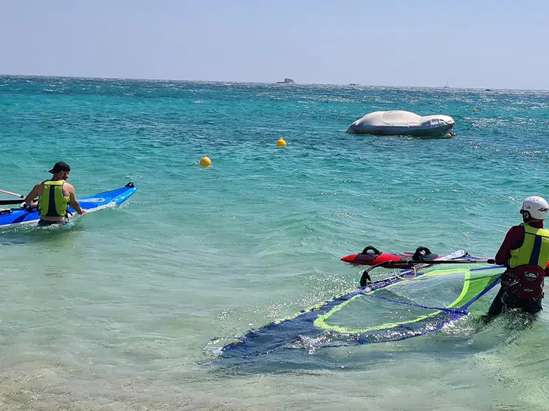 Planche à voile dans une eau turquoise peu profonde