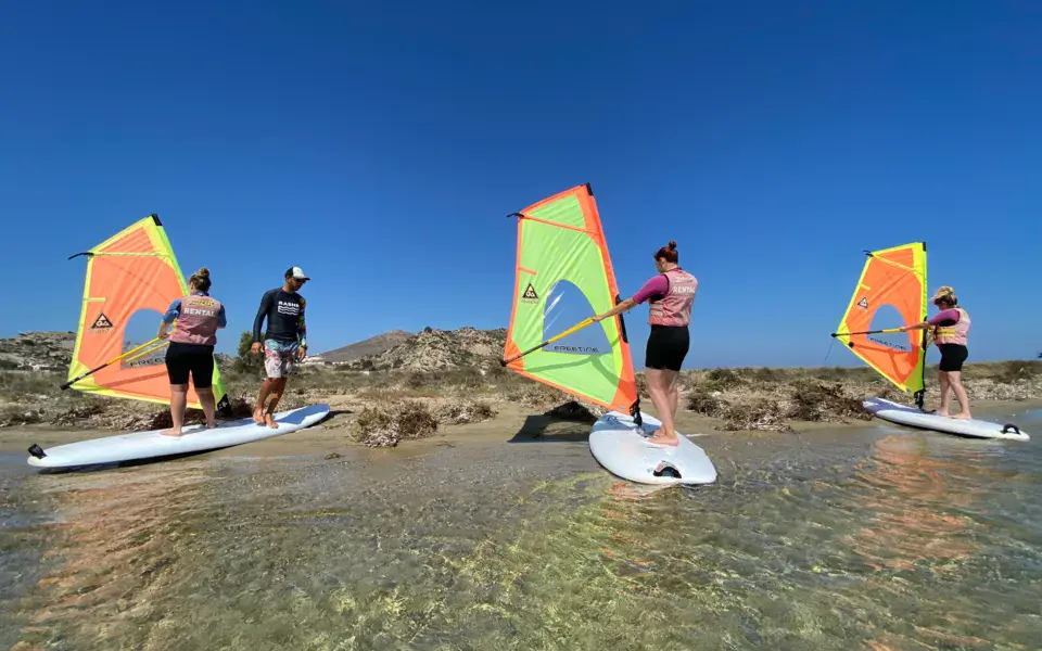 Groupe de windsurfeurs de dos dans le lagon peu profond