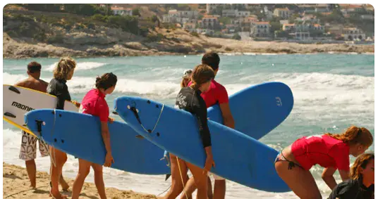 Groupe d'élèves portant leurs planches vers l'eau