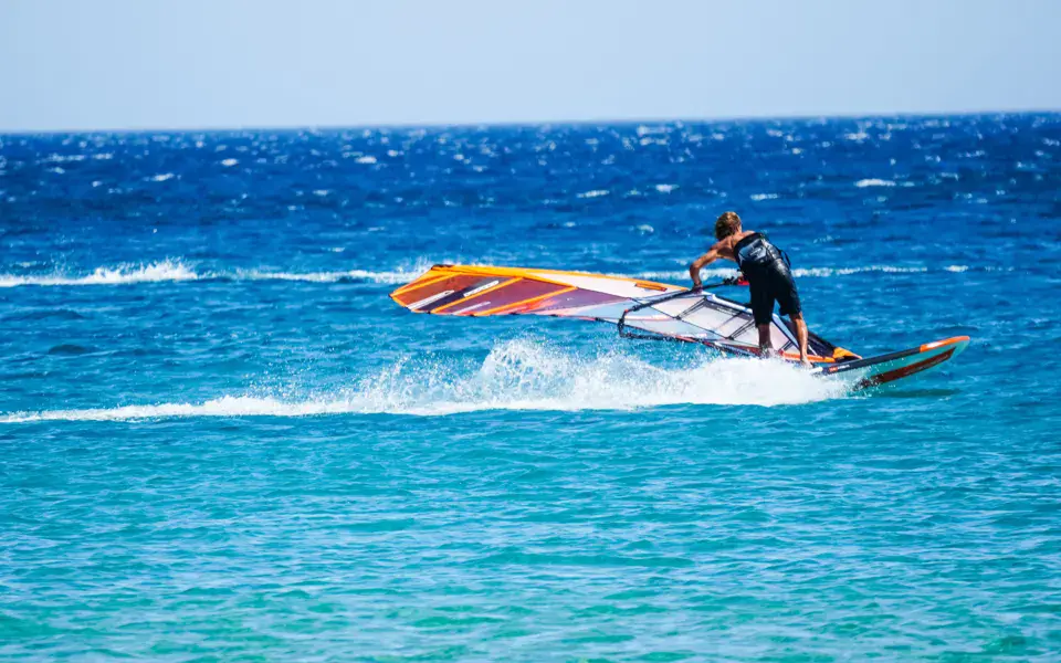 Windsurfeur en vitesse sur une eau bleue