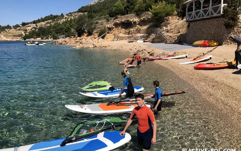 Matériel de windsurf et de paddle sur la plage de galets