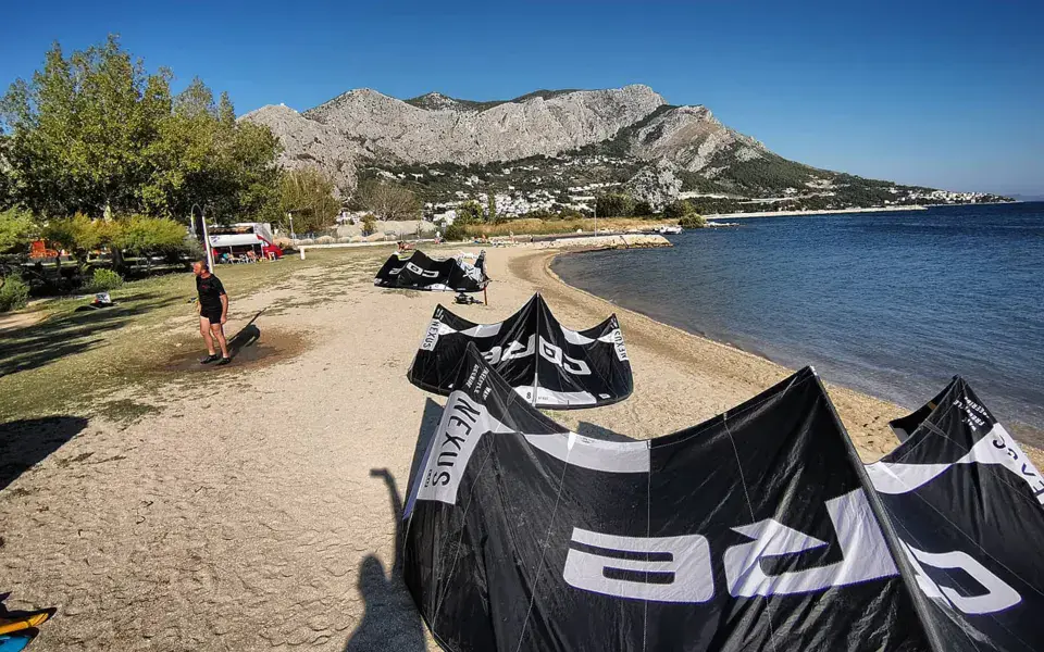 Kites posés sur la plage de sable avec les montagnes en arrière-plan