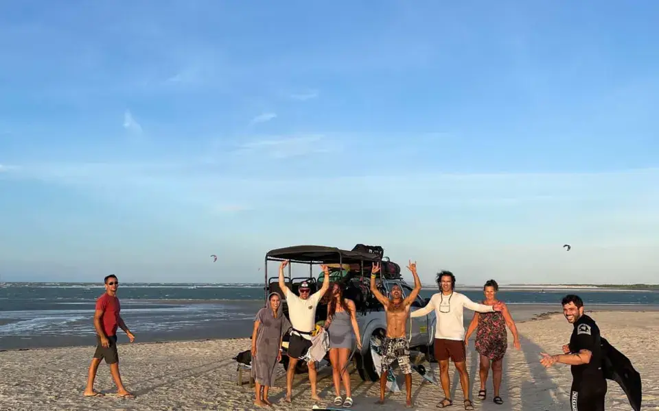 Groupe de riders sur la plage avec le véhicule de l'école