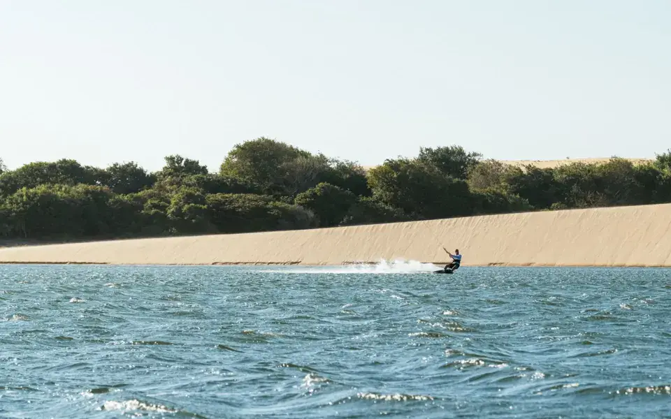 Kite jaune sur la lagune à côté d'une dune