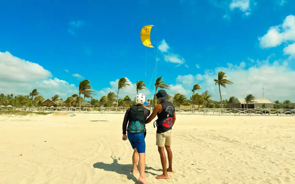 Instructeur et élève sur la plage avec une aile de kitesurf