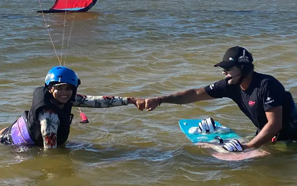 Moniteur et élève dans l'eau pendant un cours de kitesurf