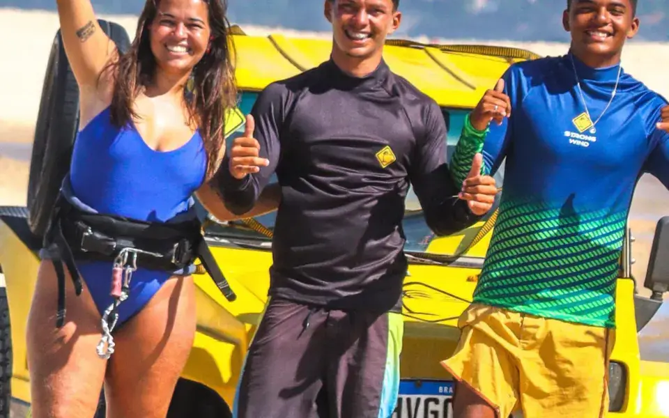 Équipe sur la plage devant un buggy