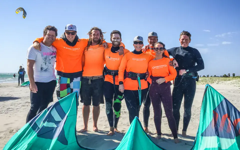 Équipe du centre de kite avec des voiles sur la plage