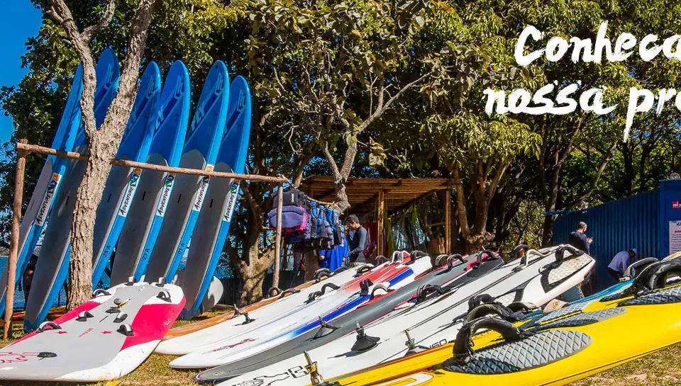 Planches de windsurf et de SUP alignées sur la plage du club