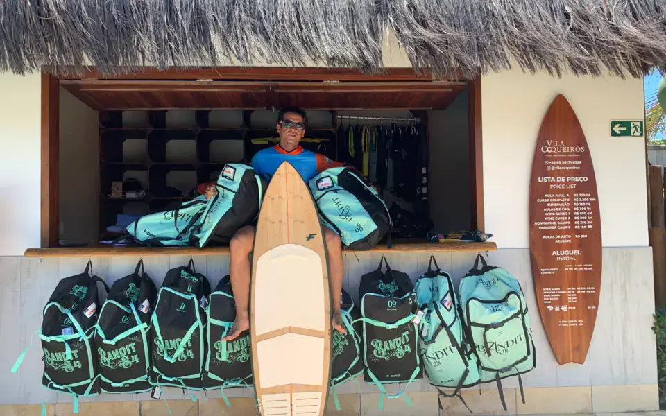 Moniteur devant le stand de l'école, avec des sacs de kite
