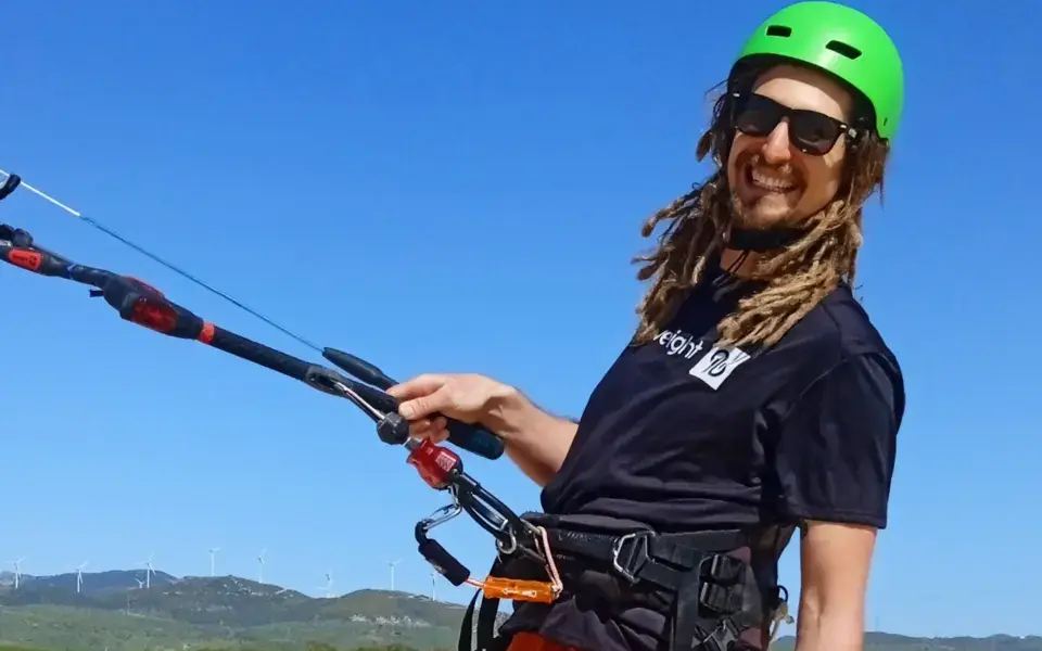 Kitesurfeur avec casque et barre sur la plage