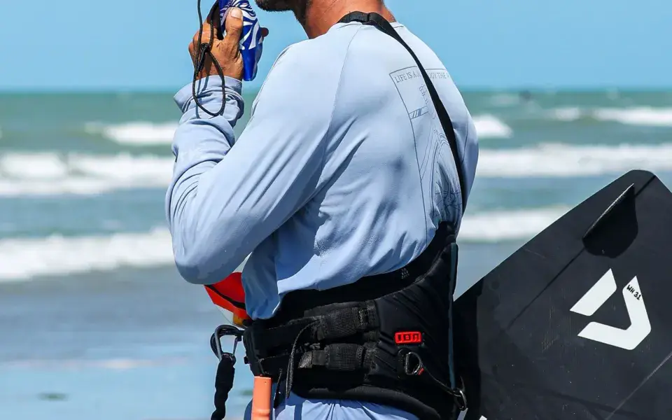 Instructeur de kitesurf avec casque radio sur la plage