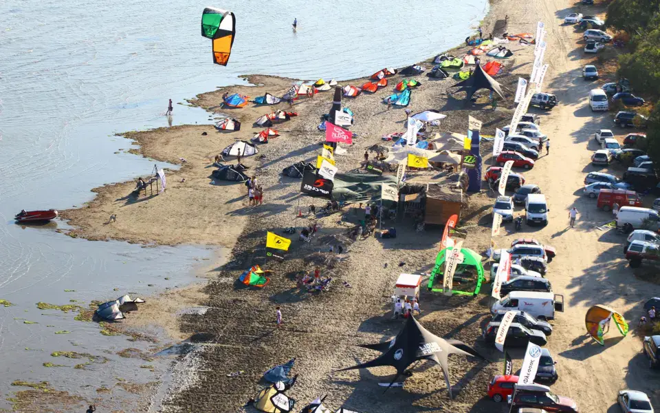 Plage de kitesurf vue du ciel, voiles et voitures le long du rivage