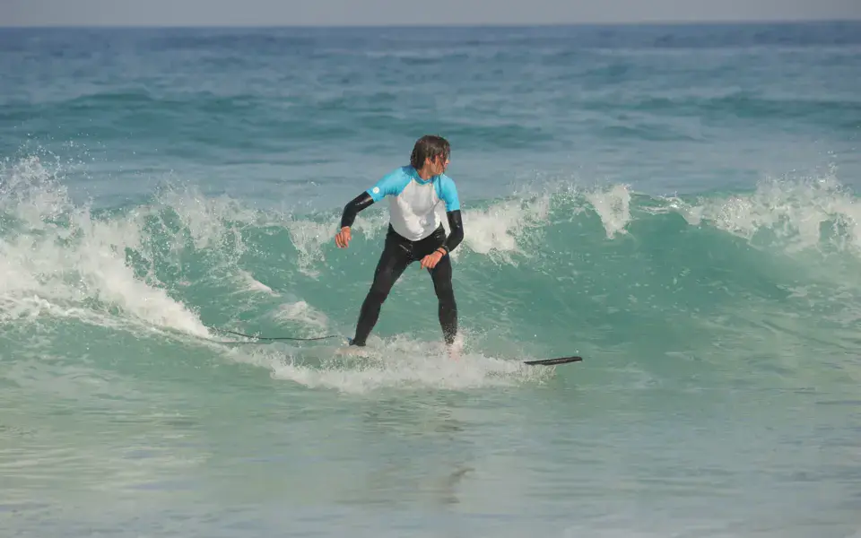 Élève surfant une vague pendant un cours