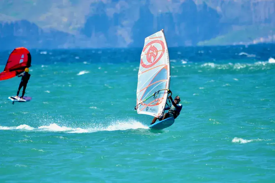 Windsurfeur et rider en wing foil au large