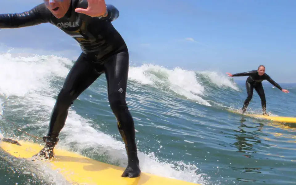 Deux surfeurs sur des planches de débutant jaunes