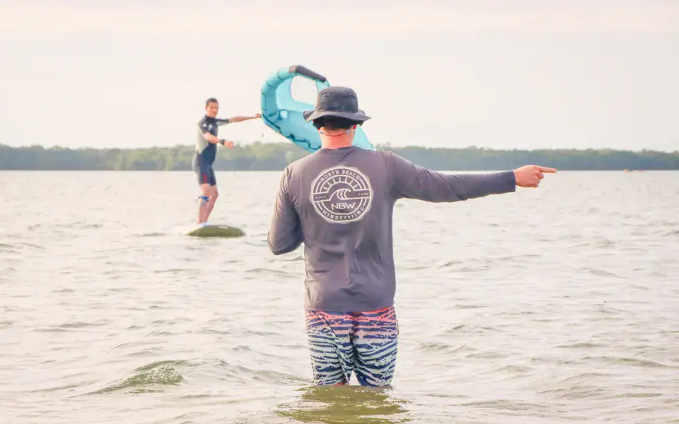 Cours de wing foil en eau peu profonde avec un moniteur