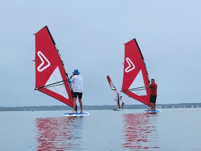 Deux planchistes sur une eau calme pendant un cours