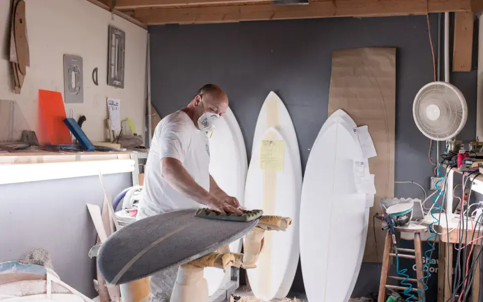Shaper au travail dans l'atelier, planches blanches en cours de fabrication