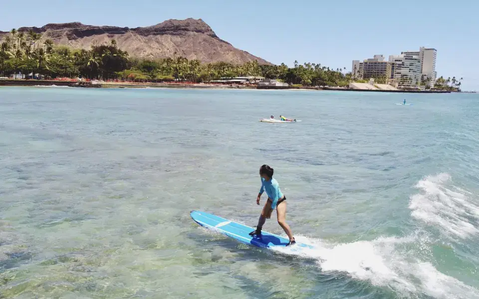 Surfeur sur une vague à Waikiki, avec Diamond Head en fond