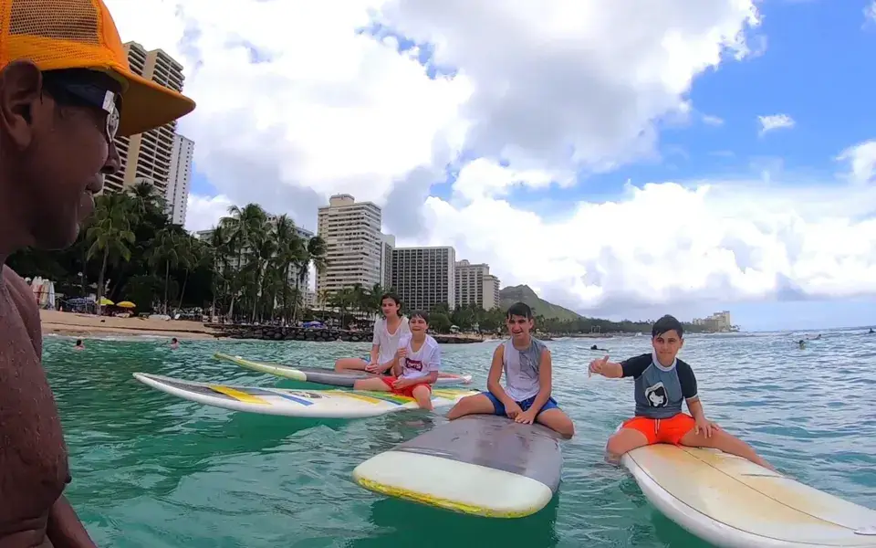 Cours de surf dans l'eau à Waikiki, avec les hôtels en fond