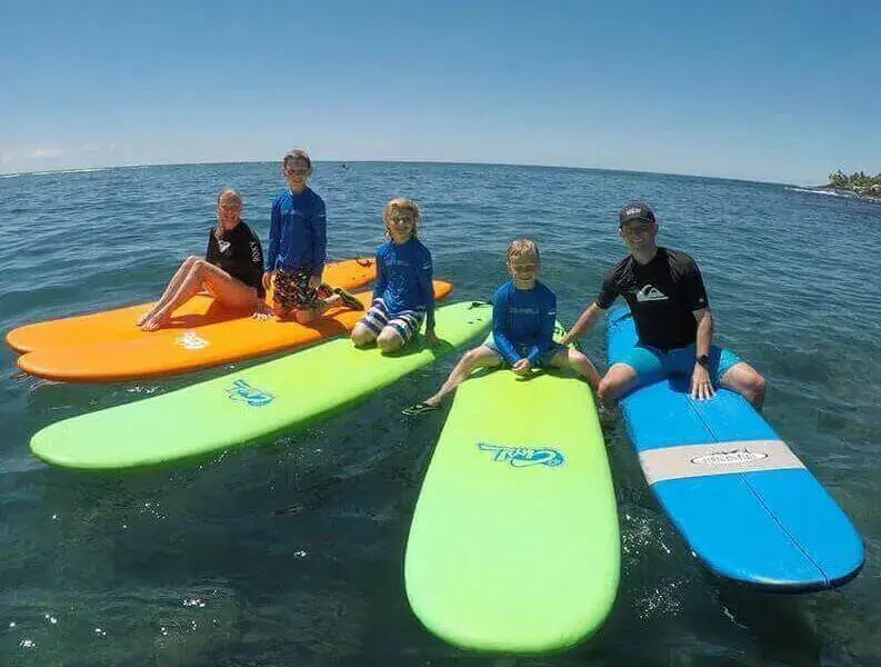 Un groupe assis sur des planches de surf, au large