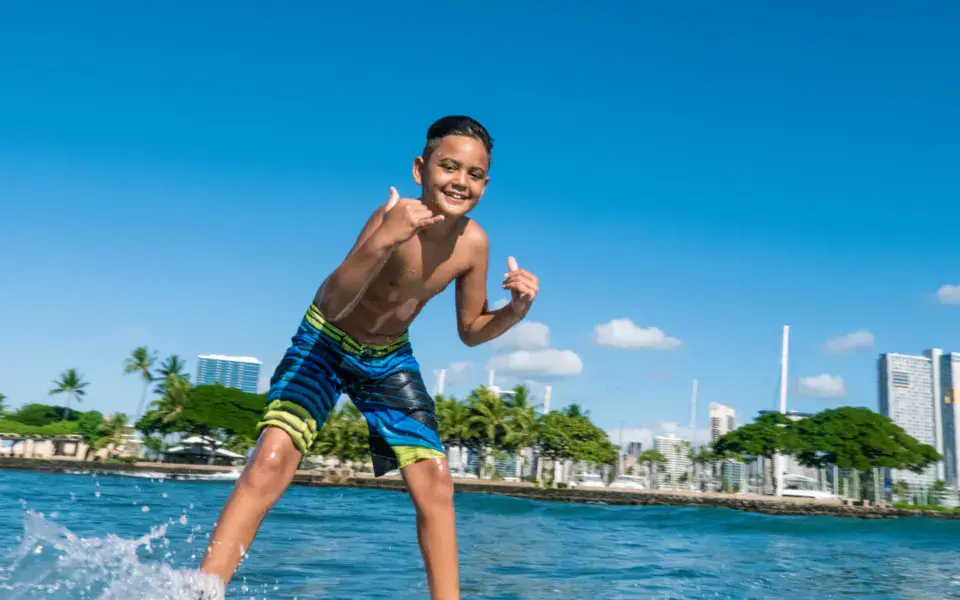 Jeune surfeur sur sa planche près de la rive