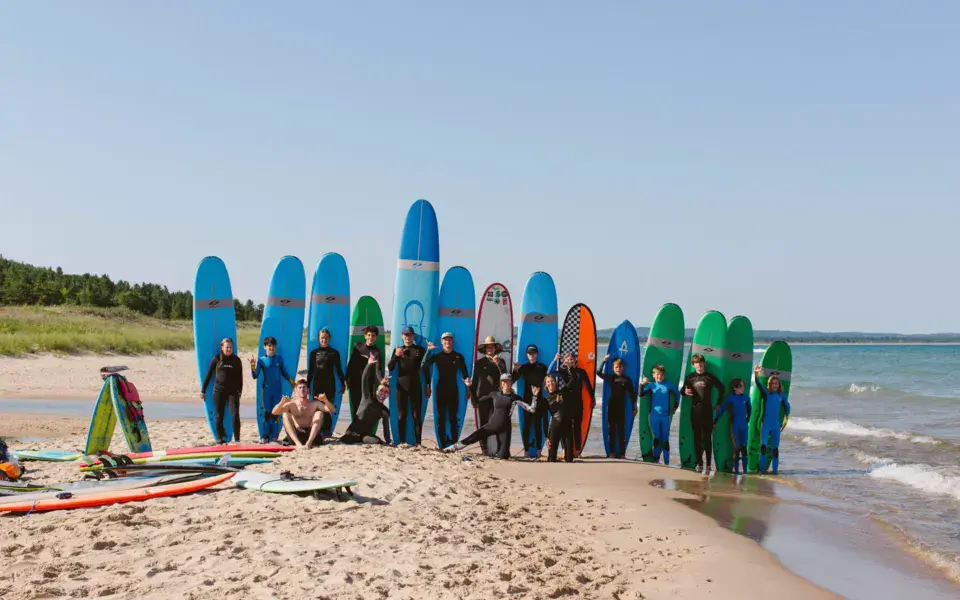 Groupe sur la plage devant une rangée de planches de surf