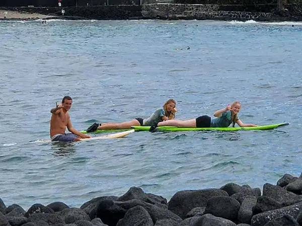 Élèves allongés sur une planche, avec un moniteur dans l'eau