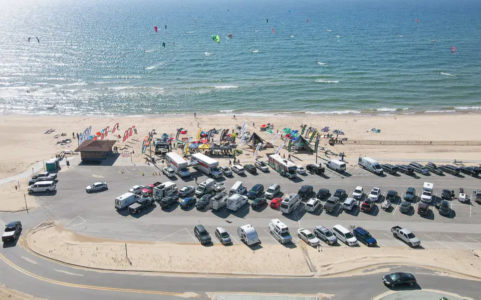 Vue aérienne d'une plage avec parking et kites dans le ciel