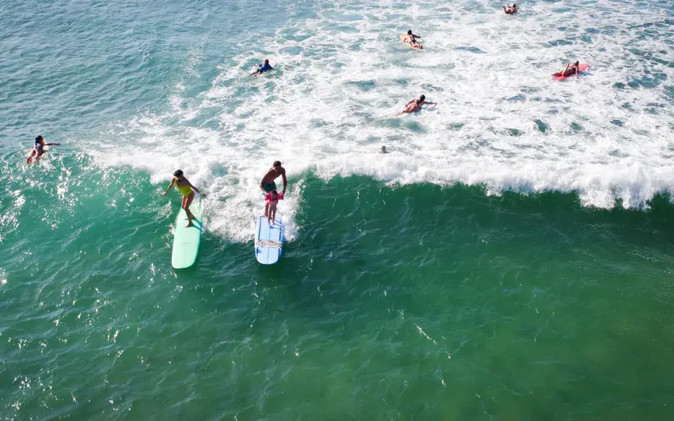 Vue aérienne d'élèves sur leurs planches dans les vagues