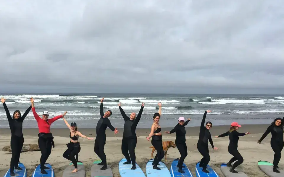 Groupe d'élèves alignés sur la plage avec leurs planches avant un cours