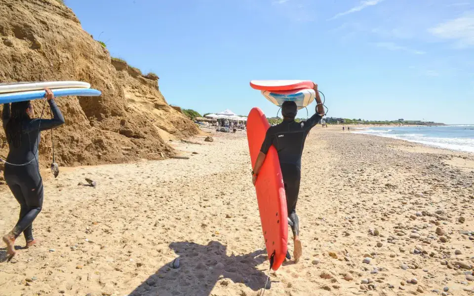 Surfeurs portant leurs planches sur la plage