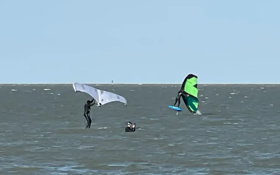 Deux pratiquants de wing foil sur l'eau