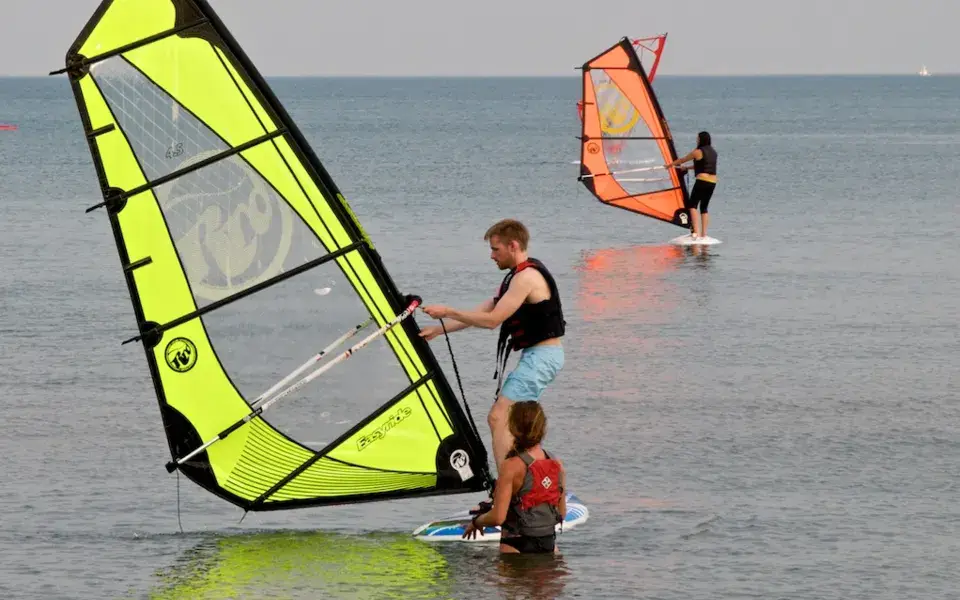 Cours de planche à voile dans le lac, un élève et son moniteur