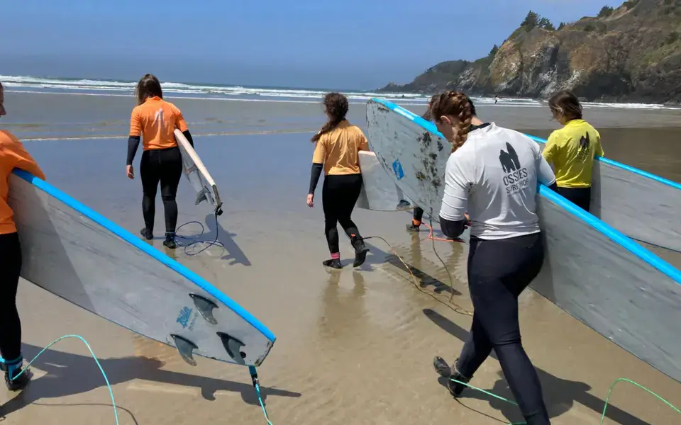 Groupe d'élèves avec des planches souples sur la plage