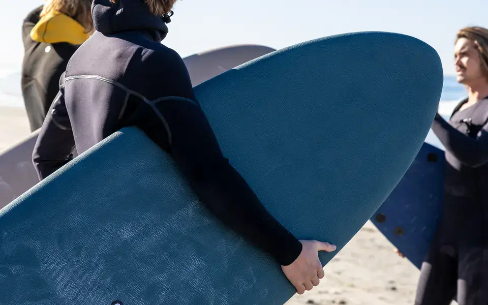 Élèves avec leurs planches sur la plage