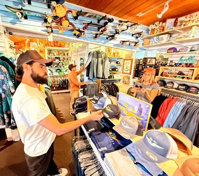 Intérieur de la boutique, rayon vêtements et casquettes