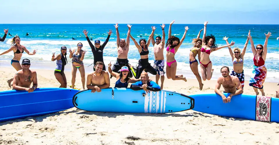 Un groupe d'élèves sur la plage avec des planches de cours