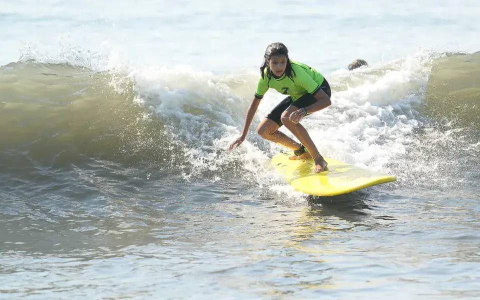 Une élève sur une vague pendant un cours de surf