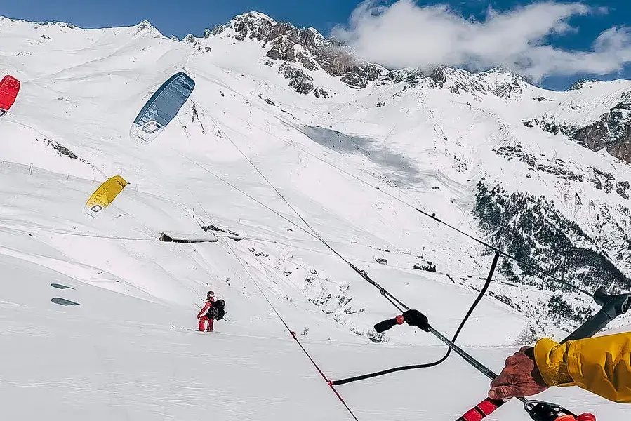 Snowkiters en montagne, ailes déployées sur la neige