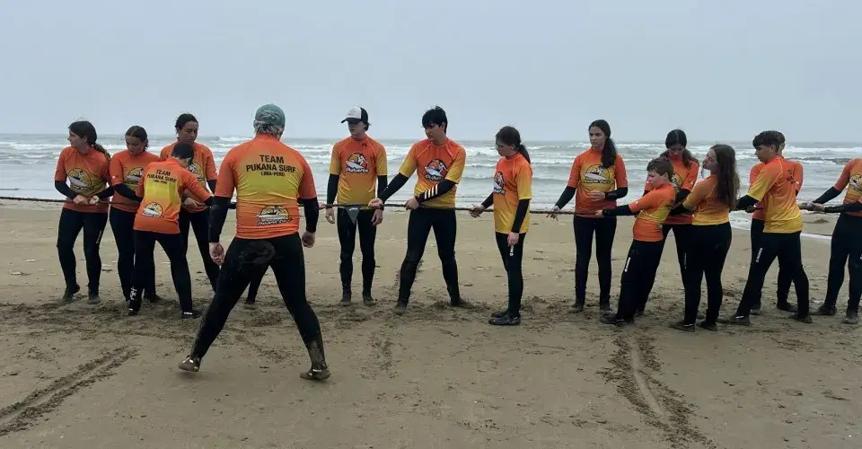 Groupe en combinaison aligné sur la plage pour l'échauffement