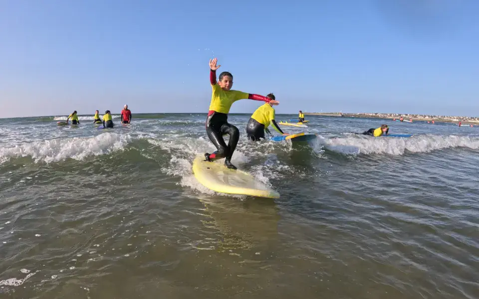Jeunes élèves debout sur leur planche dans les vagues