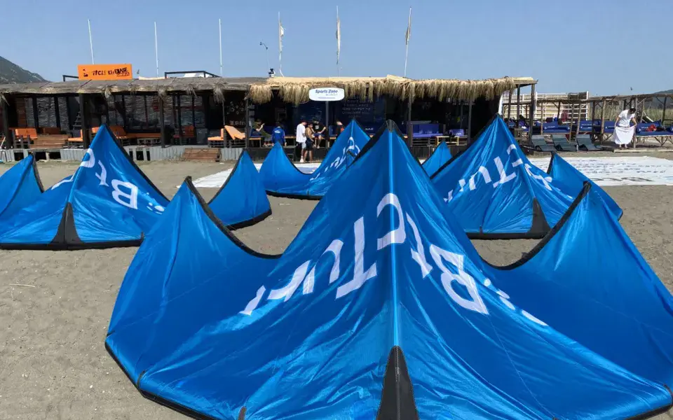 Ailes de kitesurf alignées sur la plage devant l'école