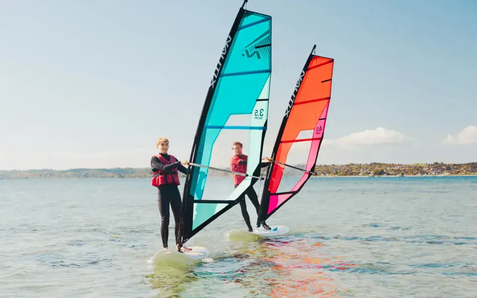 Deux élèves de windsurf sur l'eau