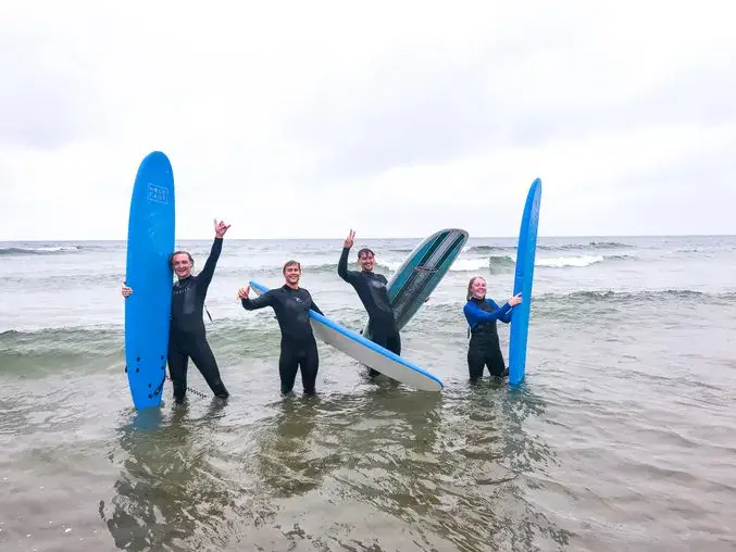 Groupe de surfeurs dans l'eau avec leurs planches