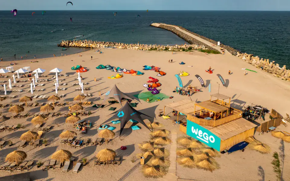 Vue aérienne d'une plage avec parasols, kites et stand de l'école