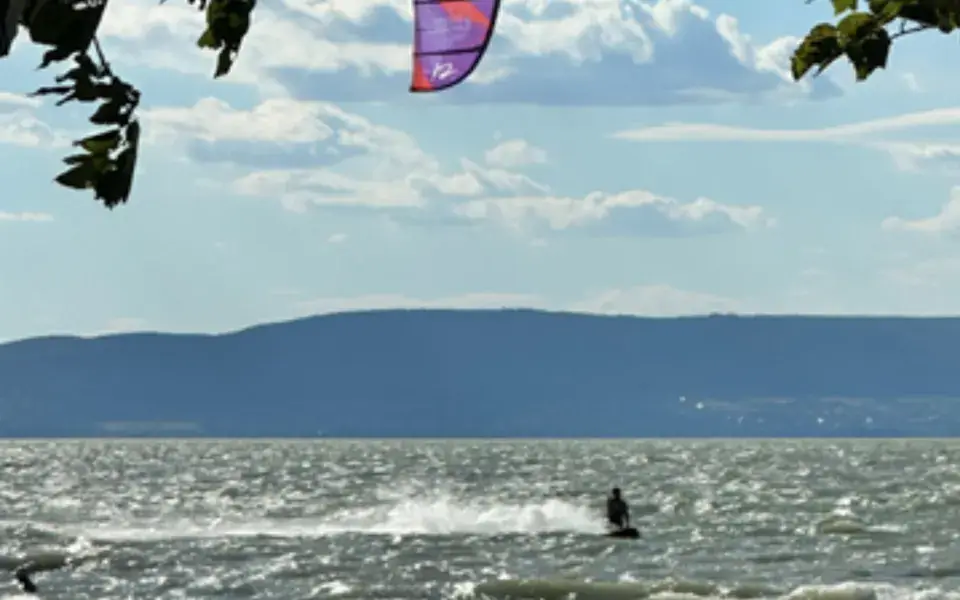 Kitesurfeur sur un lac, avec des collines au fond