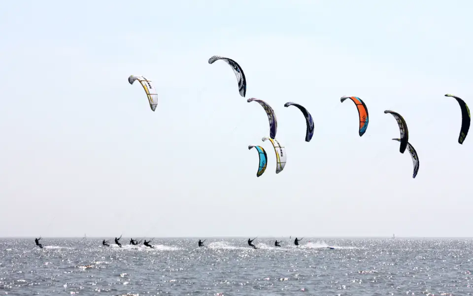 Kitesurfeurs au large, kites dans le ciel