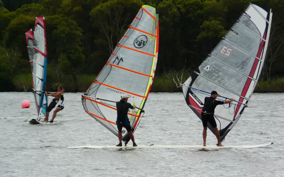 Trois windsurfeurs au départ sur le plan d'eau